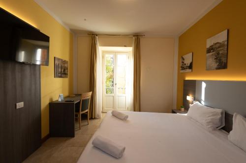 a bedroom with a bed and a desk and a window at Hotel Belvedere San Gottardo by LVG Hotel Collection in Verbania