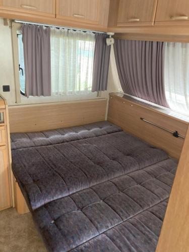a bed in the back of a small room at Каравана Макси in Chernomorets