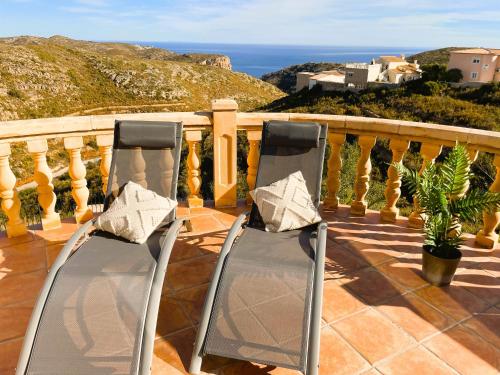 2 sillas sentadas en un balcón con vistas al océano en Mimosa Ferienhaus, en Cumbre del Sol