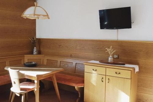 a dining room with a table and a tv at Belpra in Ortisei