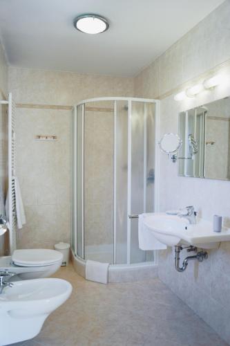a bathroom with two sinks and a shower and a toilet at Belpra in Ortisei