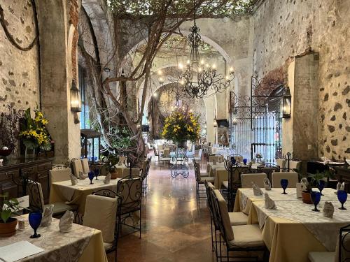 a dining room with tables and chairs and a chandelier at Hotel & Spa Hacienda de Cortés in Cuernavaca