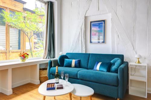un salon avec un canapé bleu et une table dans l'établissement Bluestay 303 - Superb apartment in Paris, à Paris