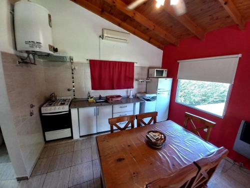 eine Küche mit einem Holztisch und eine Küche mit einem Herd in der Unterkunft Cabañas Cuncumen in Los Reartes