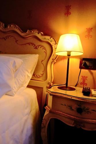 a bedroom with a bed and a lamp on a table at H O T E L S A N G A L L O l in Venice