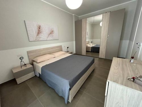 ナルドにあるLungomare Santa Caterinaのベッドと大きな鏡のある寝室