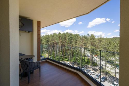 a room with a balcony with a view of trees at Zlatibor Residence & Suites in Zlatibor