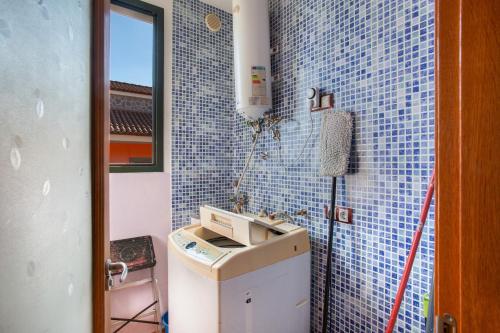 baño con lavabo y pared de azulejos azules en Villa Doramas, en Firgas