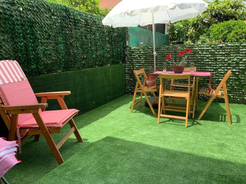 a patio with chairs and a table with an umbrella at Scarlett 22 - Intero appartamento, centro città, free wifi in Carbonia