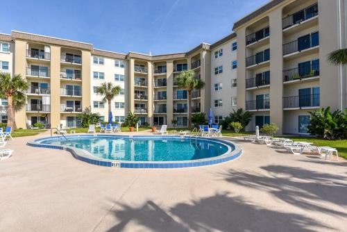 a large apartment building with a swimming pool in front of a building at King's Hideaway in Daytona Beach Shores