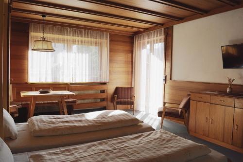 a bedroom with a bed and a table and a window at Belpra in Ortisei