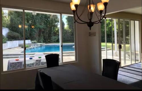 a dining room with a table and a view of a pool at Beautiful 4BD and 3BA Pool Jacuzzi Vacation Home in Los Angeles