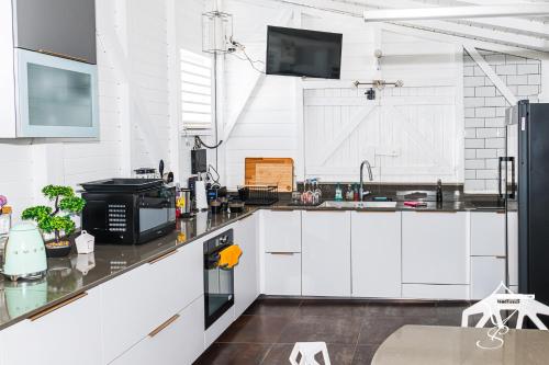 a kitchen with white cabinets and a counter top at MAISON SUNNY, Piscine chauffée et prestations haut de gamme in Schœlcher