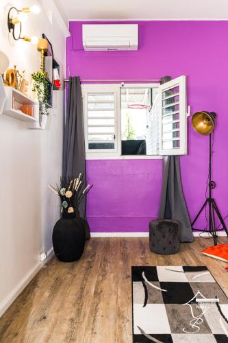 a room with a purple wall and a window at MAISON SUNNY, Piscine chauffée et prestations haut de gamme in Schœlcher