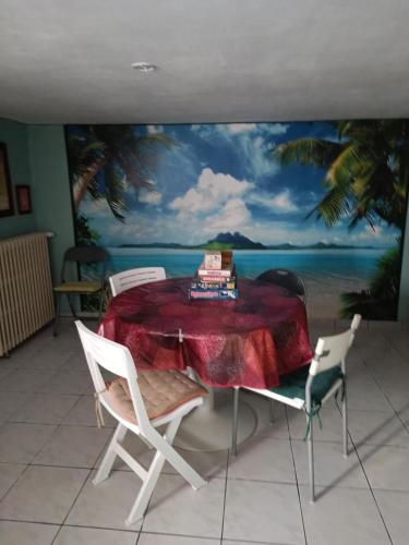 une chambre avec une table et une peinture de l'océan dans l'établissement Maison Aussillon tarn, à Aussillon