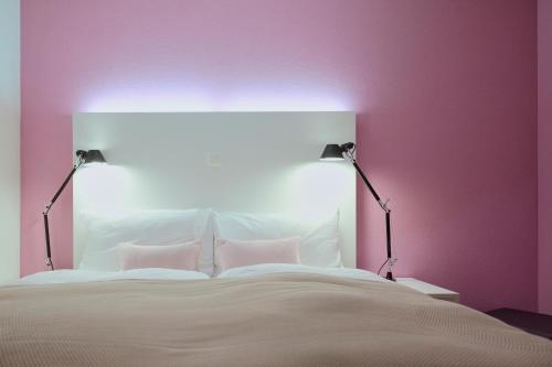 a bedroom with a white bed with two lamps at Wellness Hotel Stoos in Stoos