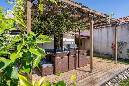 a wooden deck with chairs and a pergola at Maison de Charme en Provence avec jardin et piscine in Carpentras