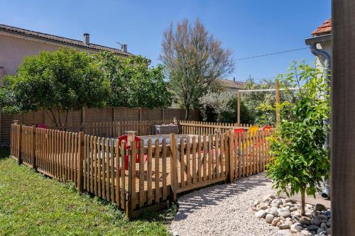 a wooden fence with fire hydrants in a yard at Maison de Charme en Provence avec jardin et piscine in Carpentras