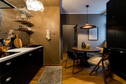 a kitchen with a table and a dining room at Downtown Calea Victoriei 100 Jacuzzi&Sauna&Bathtub in Bucharest