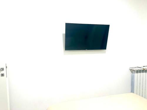 a tv on a white wall in a room at Alloggio by the sea in Focene