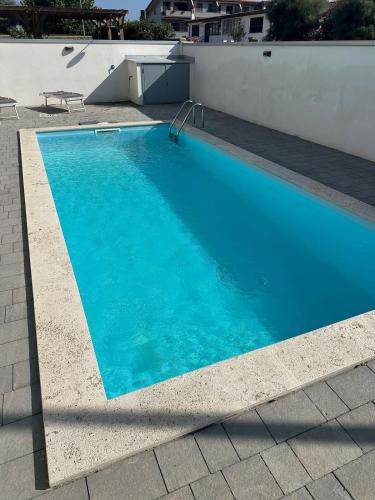a large blue swimming pool on top of a building at Alloggio by the sea in Focene