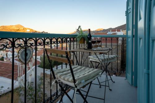 a balcony with a table and chairs on a fence at "Vela" Symi Village Residences in Symi