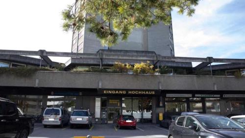 a parking lot with cars parked in front of a building at Solution-Grischun Apartments - Berninaexpress - Städterip - atemberaubende Aussicht in Chur