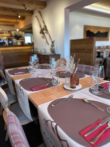 a set of tables in a restaurant with plates and glasses at Chalet Sepp in Belalp