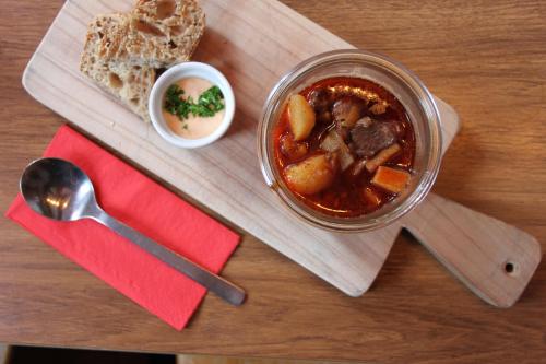 a table with a jar of stew and a plate of bread at Chalet Sepp in Belalp