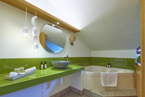 a bathroom with a tub and a sink at Wellness Hotel Stoos in Stoos