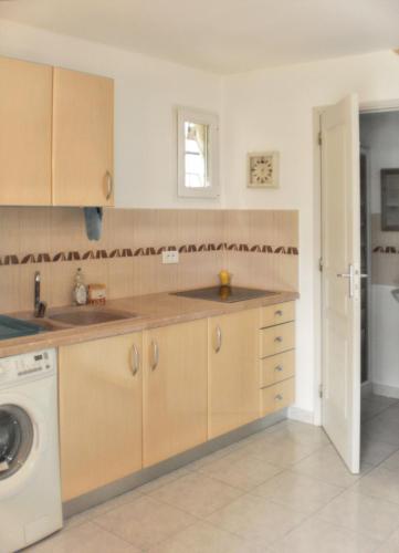 une cuisine avec un évier et une machine à laver dans l'établissement Maison charmante à Poggio-Mezzana avec vue mer, à Poggio-Mezzana