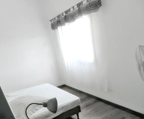 a white room with a bed and a window at Maison charmante à Poggio-Mezzana avec vue mer in Poggio-Mezzana
