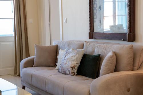 a couch with pillows on it in a living room at "Vela" Symi Village Residences in Symi