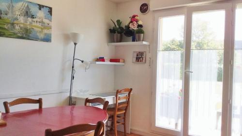 une salle à manger avec une table et une fenêtre dans l'établissement Appartement charmant à Carentan les Marais, 40 m² avec terrasse, à Carentan