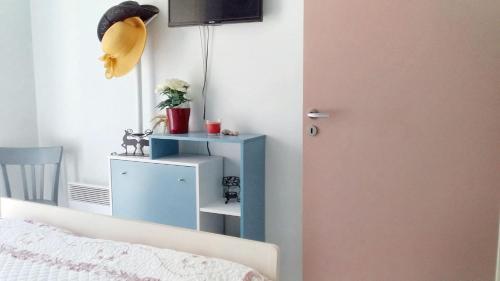 - une chambre avec une armoire bleue à côté d'un lit dans l'établissement Appartement charmant à Carentan les Marais, 40 m² avec terrasse, à Carentan