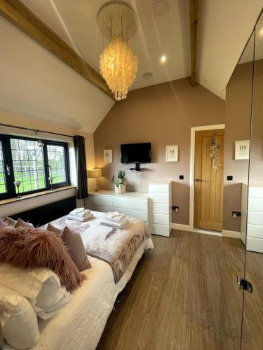 a bedroom with a large bed and a chandelier at Sunset Cottage in Warwick