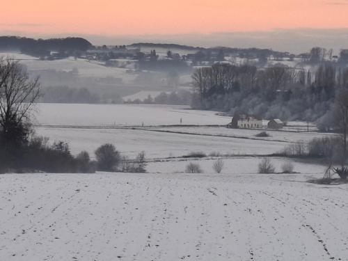 a field covered in snow with a city in the background at Hakunamatata in Mainvault