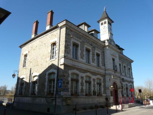 un ancien bâtiment en brique avec une tour d'horloge en haut dans l'établissement Grand Jardin Maison Spacieuse Idéale pour Famille, à Larche