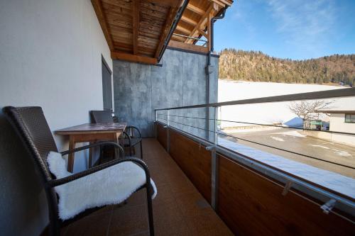 a balcony with a chair and a table and a view at Hotel Garni Tirol in Walchsee
