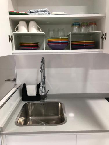 a kitchen counter with a sink and plates and bowls at La Casilla del Molino in Almodóvar del Río