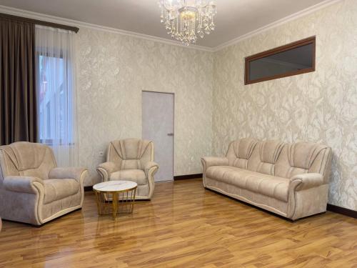 a living room with two chairs and a chandelier at Golden Kapan in Kapan