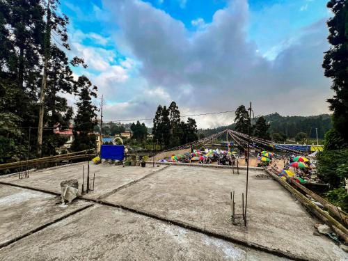 a group of people sitting on a bridge with a playground at Rise And Shine Homestay in Mirik