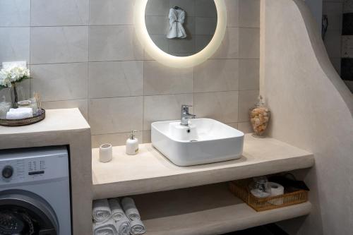 a bathroom with a sink and a washing machine at "Vela" Symi Village Residences in Symi