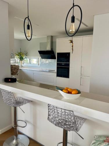 a kitchen with a bowl of oranges on a counter at Vila Da Luz Calheta in Estreito da Calheta