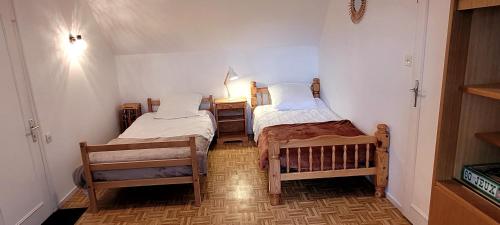 Cette petite chambre comprend deux lits et une lampe. dans l'établissement Maison à 400m de la plage, pour 6 personnes, à Penvénan