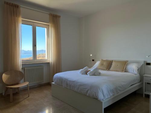 a bedroom with a large white bed with a window at Appartamenti Cipriani in Cavaion Veronese