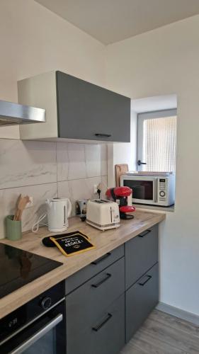 une cuisine avec un comptoir avec un micro-ondes dans l'établissement T3 au Centre de Gourdon, à Gourdon