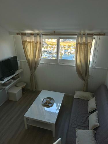 TV a/nebo společenská místnost v ubytování Aux beaux coquillages, vue mer et sur le port