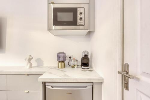 - une cuisine blanche avec un four micro-ondes et un comptoir dans l'établissement Suite Love Hammam et Sauna, à Les Pavillons-sous-Bois