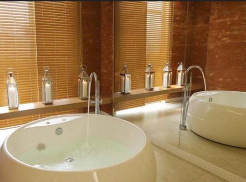 a bathroom with a tub and a sink with candles at Top Flat confortavel e muito bem localizado in Brasília